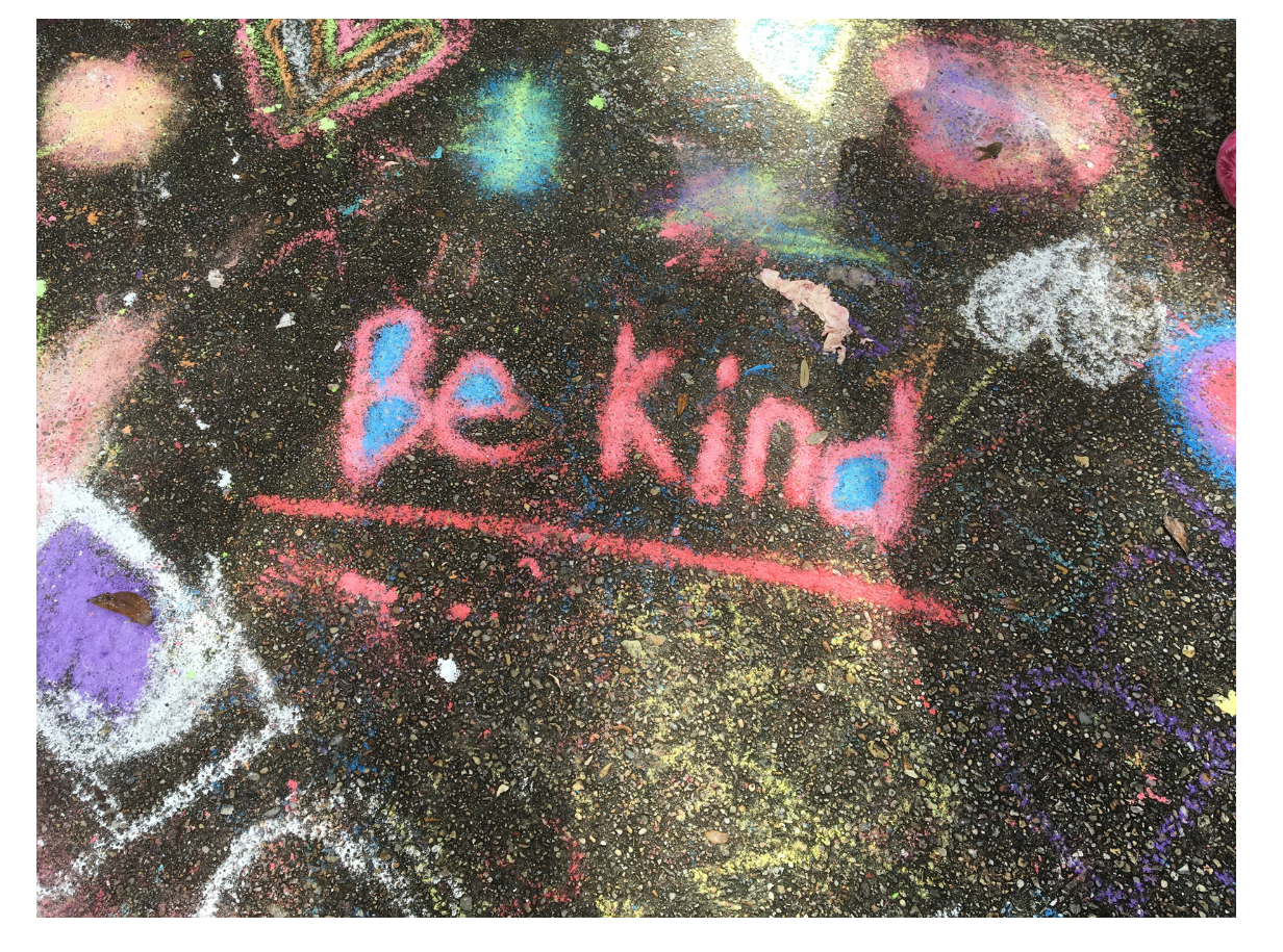 Chalk Drawing Be Kind Pink chalk on a side walk spells out "Be Kind" amongst other chalk doodles.